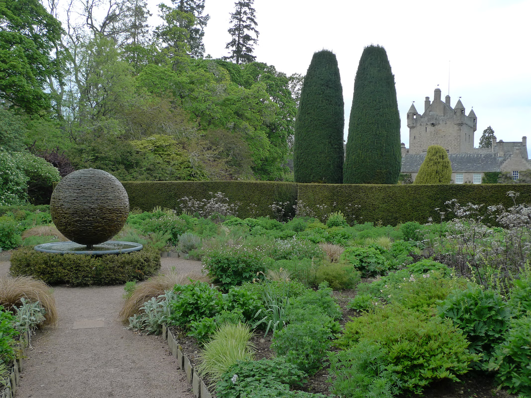 Cawdor Castle gardens with a fountain and the castle tower in the background