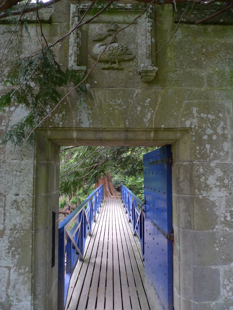 Blue door and blue bridge that go to woodland walks at Cawdor Castle