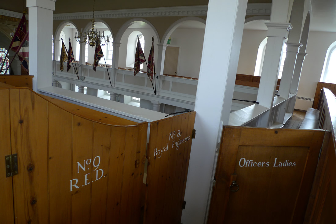 Inside the chapel at Fort George. The upper gallery is divided into private seating areas. Doors have white lettering to say who can sit there. The doors have officers ladies, no.8 royal engineers and no.9 R.E.D written on them