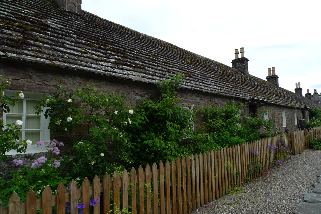 Cottages in Glamis. They have small front gardens with a fence and flowers
