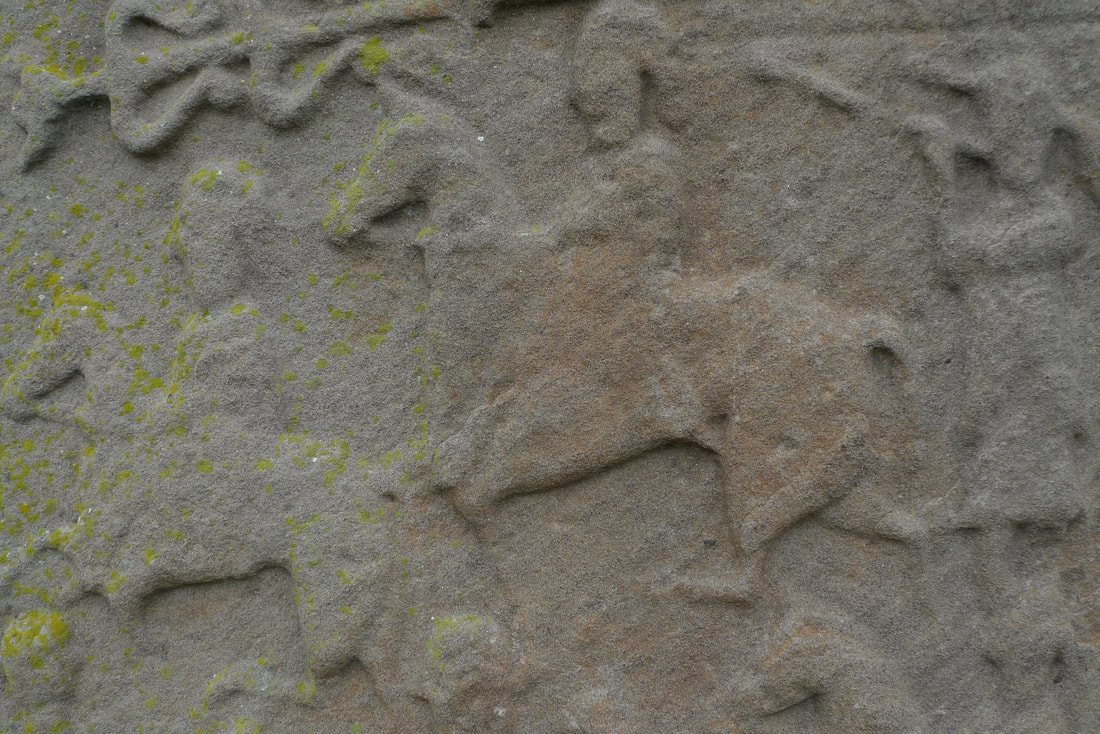 Adegan pertempuran di salah satu batu berdiri Aberlemno.  Ini memiliki angka di atas kuda