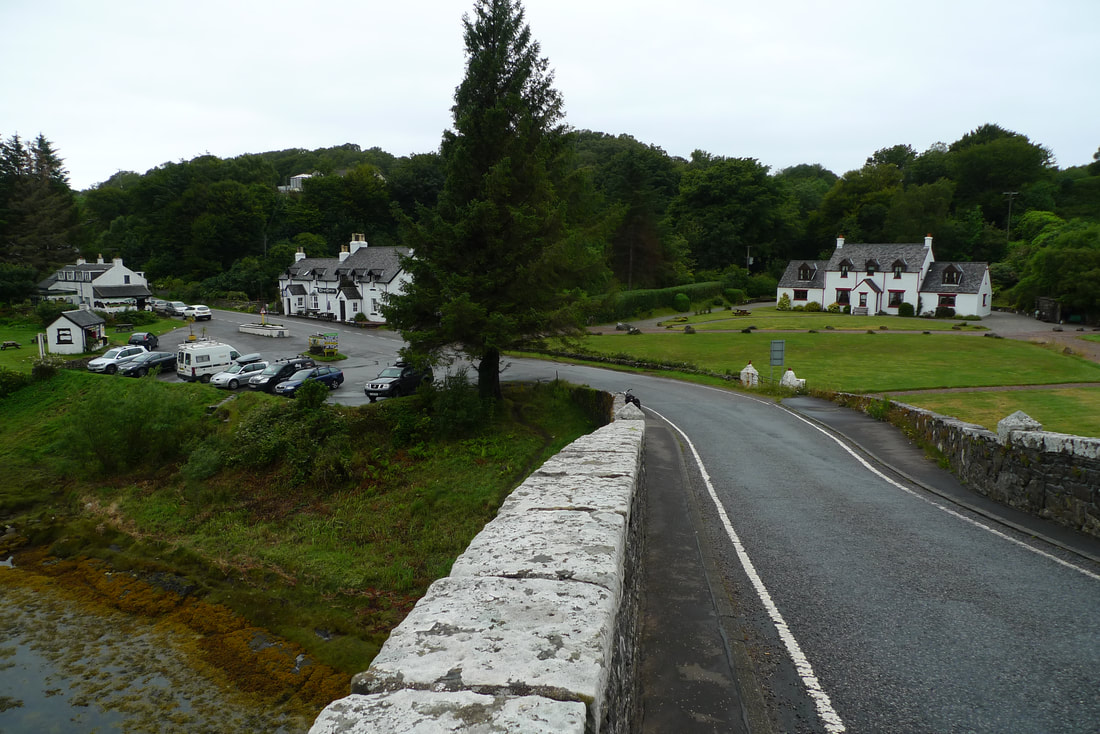 A view of white houses and fields from The Clachan Bridge