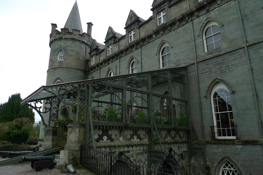 The entrance to Inveraray Castle. A decorative iron canopy filled with flowers and plants