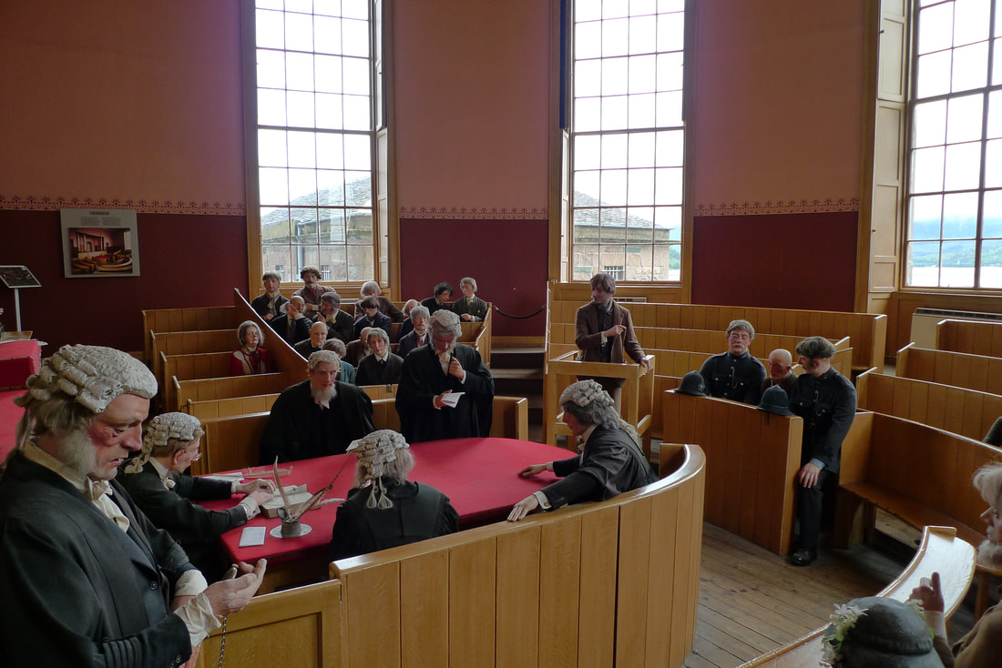 The courtroom in Inverary Jail. It is filled with mannequins dressed in period costume.