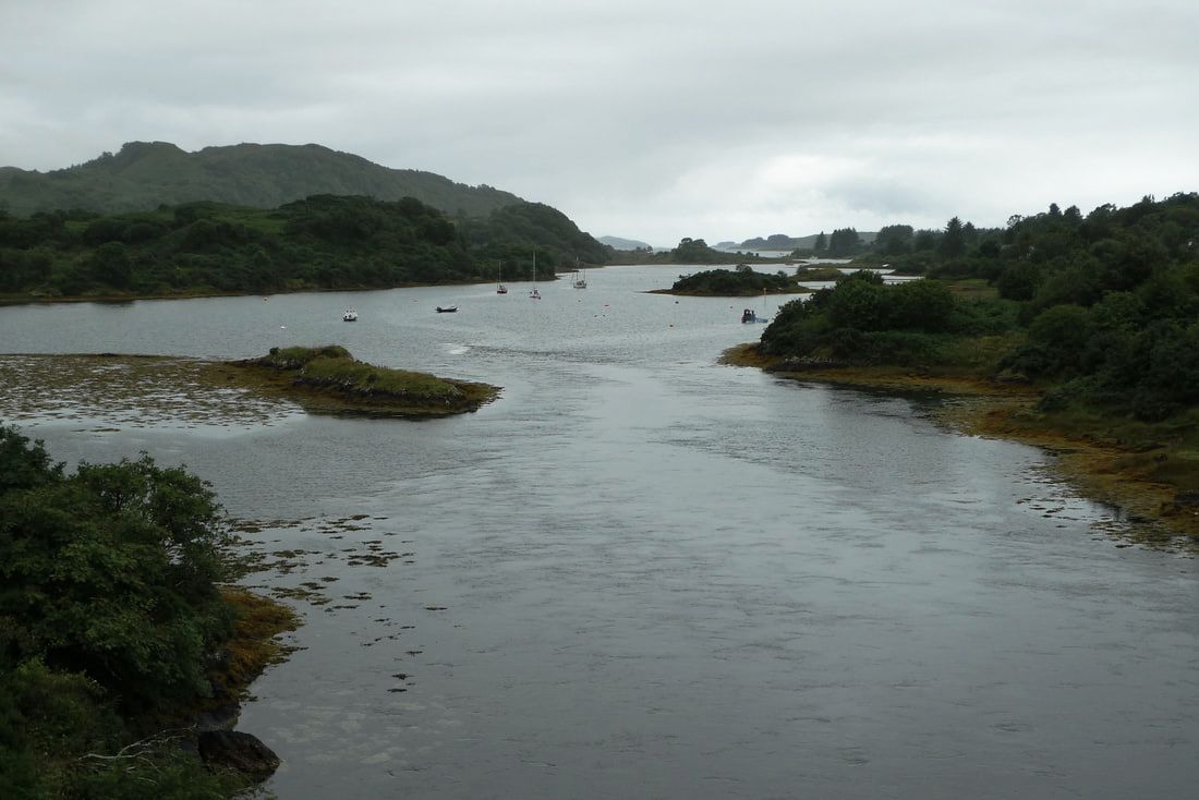 The view from the top of the 'bridge over the Atlantic'. There are islands, boats and hills